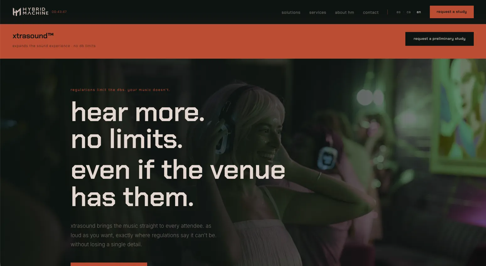 Web de Hybrid Machine: asistente a un evento escuchando música con auriculares xtrasound™